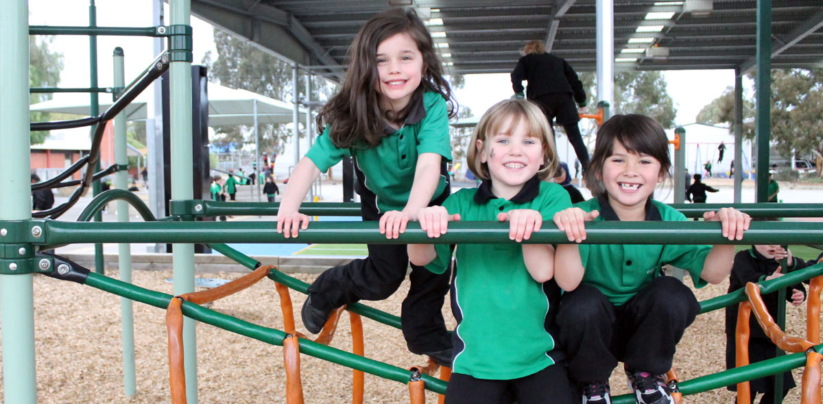 A group of students smiling on play equipment